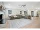 Well-lit living room with a fireplace, large gray sectional, ceiling fan, and modern decor at 12001 Backwater Rd, Sarasota, FL 34240