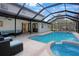 A beautiful screened-in pool area with a pool, hot tub, and patio furniture at 12001 Backwater Rd, Sarasota, FL 34240