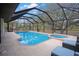 Screened in pool and hot tub with a view of the property's trees and landscaping at 12001 Backwater Rd, Sarasota, FL 34240