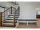Staircase with wood stairs and metal railing, complemented by a built-in bench for added convenience at 12001 Backwater Rd, Sarasota, FL 34240