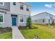Well-kept home exterior with blue door, beautiful green landscaping, and lush, green lawns at 16606 San Nicola Pl, Lakewood Ranch, FL 34211