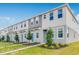 Well-maintained two-story townhomes with blue front doors, lush lawns, and vibrant green space at 16606 San Nicola Pl, Lakewood Ranch, FL 34211