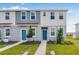 Charming two-story townhomes with blue front doors, well-manicured lawns, and vibrant green space at 16606 San Nicola Pl, Lakewood Ranch, FL 34211