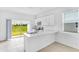 Bright, modern kitchen with white cabinets, stainless appliances, and sliding glass doors at 16606 San Nicola Pl, Lakewood Ranch, FL 34211