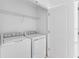 Bright laundry room featuring a washer, dryer, wire shelving and a white door at 16606 San Nicola Pl, Lakewood Ranch, FL 34211