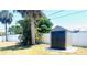 Backyard featuring storage shed, palm trees, surrounded by a white privacy fence at 241 Seminole Nw Blvd, Port Charlotte, FL 33952