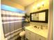Bright bathroom with a vanity, decorative shelves, and a shower with a striped curtain at 241 Seminole Nw Blvd, Port Charlotte, FL 33952