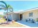 Charming single-story home featuring stone accents, a well manicured lawn, and mature palm trees at 241 Seminole Nw Blvd, Port Charlotte, FL 33952