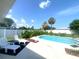 Outdoor pool area featuring lounge chairs and well-maintained landscaping and a clear blue sky at 241 Seminole Nw Blvd, Port Charlotte, FL 33952