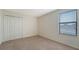 A simply decorated bedroom with carpet, a closet, and a window with blinds at 3628 Scrub Creek Run, Bradenton, FL 34211