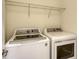 Well-equipped laundry area with modern washer and dryer, plus overhead shelving for storage at 3628 Scrub Creek Run, Bradenton, FL 34211