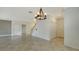 Neutral-colored living room boasts tile floors, a modern light fixture and staircase to the second floor at 3628 Scrub Creek Run, Bradenton, FL 34211