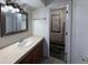 Bathroom with a vanity featuring granite countertops, a decorative mirror, and a tiled shower at 1007 Longfellow Cir, Sarasota, FL 34243
