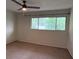 Bright, carpeted bedroom with a window view of the trees and ample natural light at 1007 Longfellow Cir, Sarasota, FL 34243