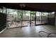 Tiled patio with screen surround overlooking the backyard and mature trees at 1007 Longfellow Cir, Sarasota, FL 34243