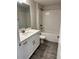 Well-lit bathroom featuring a shower-tub combination, modern vanity, and neutral-toned tiling at 2644 Averland Loop, North Port, FL 34287