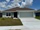 Charming single-story home with a well-manicured lawn and a two-car garage under a partly cloudy sky at 2644 Averland Loop, North Port, FL 34287