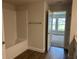 Well-lit bathroom featuring wood-look floors, a tub, and a doorway leading to a bedroom at 2648 Averland Loop, North Port, FL 34287