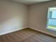 A clean bedroom features neutral carpet, walls, and a window that offers natural light at 2648 Averland Loop, North Port, FL 34287