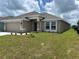 Shows home's exterior, featuring a neutral stucco finish, a two-car garage, and a well-manicured lawn at 2648 Averland Loop, North Port, FL 34287