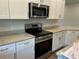 Well-equipped kitchen features stainless steel appliances, white cabinets, and granite countertops at 2648 Averland Loop, North Port, FL 34287