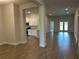 Bright living room showcasing wood-look tile flooring, access to kitchen, and sliding glass doors to the lanai at 2648 Averland Loop, North Port, FL 34287