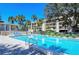 Outdoor pool with palm trees, lounge chairs, and access to a charming residential building in a tropical setting at 4600 Gulf Of Mexico Dr # 206, Longboat Key, FL 34228