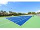Well-maintained tennis court with bright blue surface and green surroundings at 4600 Gulf Of Mexico Dr # 206, Longboat Key, FL 34228