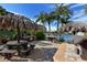 Relaxing outdoor barbeque area featuring a picnic table under a tiki hut and water view at 5740 Midnight Pass Rd # 307, Sarasota, FL 34242