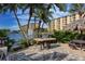 Outdoor barbecue area with picnic table, water view, and shade at 5740 Midnight Pass Rd # 307, Sarasota, FL 34242