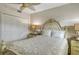 Bright bedroom with ornate bed frame, ceiling fan, and double door closet at 5740 Midnight Pass Rd # 307, Sarasota, FL 34242