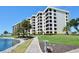 Condominium buildings with a serene pond view, lush landscaping, and a pathway for residents at 5740 Midnight Pass Rd # 307, Sarasota, FL 34242