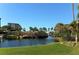 Beautiful community featuring lush landscaping, a serene lake, and a charming bridge under a clear blue sky at 5740 Midnight Pass Rd # 307, Sarasota, FL 34242