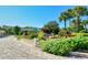 Scenic community entrance featuring lush landscaping, palm trees and a paver entrance drive at 5740 Midnight Pass Rd # 307, Sarasota, FL 34242
