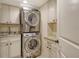 Well-equipped laundry room featuring a stacked washer/dryer and granite counters at 5740 Midnight Pass Rd # 307, Sarasota, FL 34242
