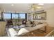 Living area with comfortable seating, a ceiling fan, and large windows at 5740 Midnight Pass Rd # 307, Sarasota, FL 34242