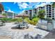 Outdoor picnic area featuring tiki umbrellas, a grill, tables, benches, and lush landscaping at 5740 Midnight Pass Rd # 307, Sarasota, FL 34242