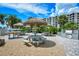 Inviting outdoor picnic area with tiki umbrellas, tables, benches, a grill, and lush landscaping at 5740 Midnight Pass Rd # 307, Sarasota, FL 34242