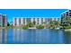 A waterfront view of the condominium complex building and a walkway with benches on the landscaped property at 5740 Midnight Pass Rd # 307, Sarasota, FL 34242