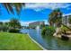 Picturesque pond view with a fountain, bridge, surrounding lush green landscaping, and tropical plants at 5740 Midnight Pass Rd # 307, Sarasota, FL 34242