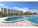 Community pool featuring resort-style lounging and beautiful buildings beyond at 5740 Midnight Pass Rd # 307, Sarasota, FL 34242