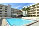 Exterior view of building and pool area on a sunny day at 5740 Midnight Pass Rd # 307, Sarasota, FL 34242
