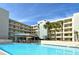 Exterior view of building and pool area with blue skies and sunny day at 5740 Midnight Pass Rd # 307, Sarasota, FL 34242