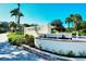 Community sign with fountain and tropical landscaping at the Gulf & Bay Club at 5740 Midnight Pass Rd # 307, Sarasota, FL 34242