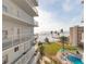 Balcony view of the beach, tropical landscaping, and community pool at 5830 Midnight Pass Rd # 502, Sarasota, FL 34242