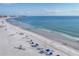 Serene beach with clear blue ocean water, umbrellas, and sunbathers at 5830 Midnight Pass Rd # 502, Sarasota, FL 34242