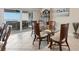 Bright dining area with glass table and seating, with a view to the water from sliding doors at 5830 Midnight Pass Rd # 502, Sarasota, FL 34242