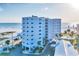 Beachside condo building with balconies and ocean views, parking and tropical landscaping at 5830 Midnight Pass Rd # 502, Sarasota, FL 34242