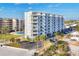 White condo building with multi-level balconies, palm trees, and a well-maintained parking area at 5830 Midnight Pass Rd # 502, Sarasota, FL 34242