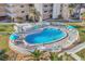 Aerial view of the kidney-shaped community pool with ample lounge chairs at 5830 Midnight Pass Rd # 502, Sarasota, FL 34242
